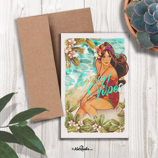 5x7 greeting card featuring an illustration of a surfer girl sitting on a beach surrounded by a plumeria tree. The message on the front of the card reads “Aloha Vibes". A kraft paper envelope is included with card. 