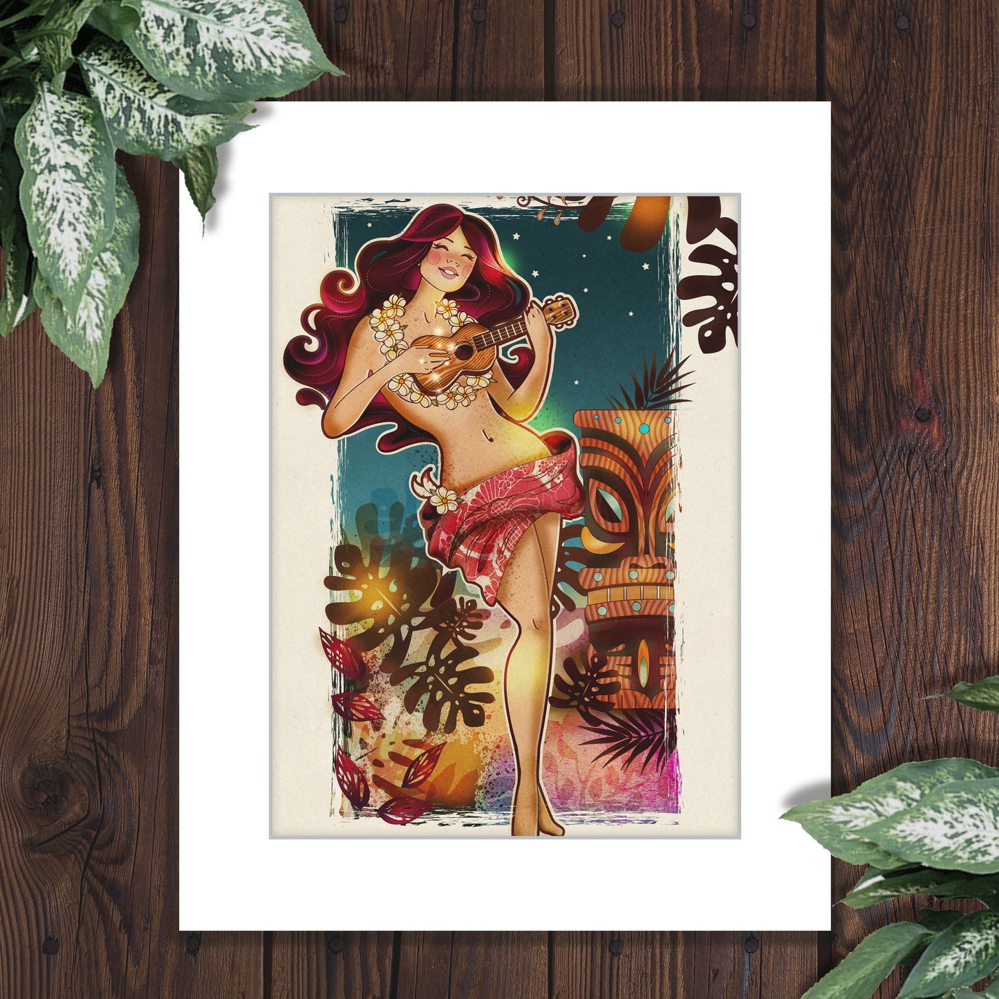 a tiki style illustration of a red haired hula girl playing the ukulele at night. She is framed by a tiki and abstract monstera leaves and a distressed white frame